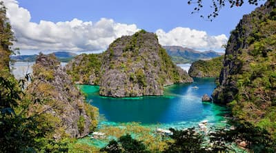 Kayangan Lake's turquoise cove ringed by limestone, Coron