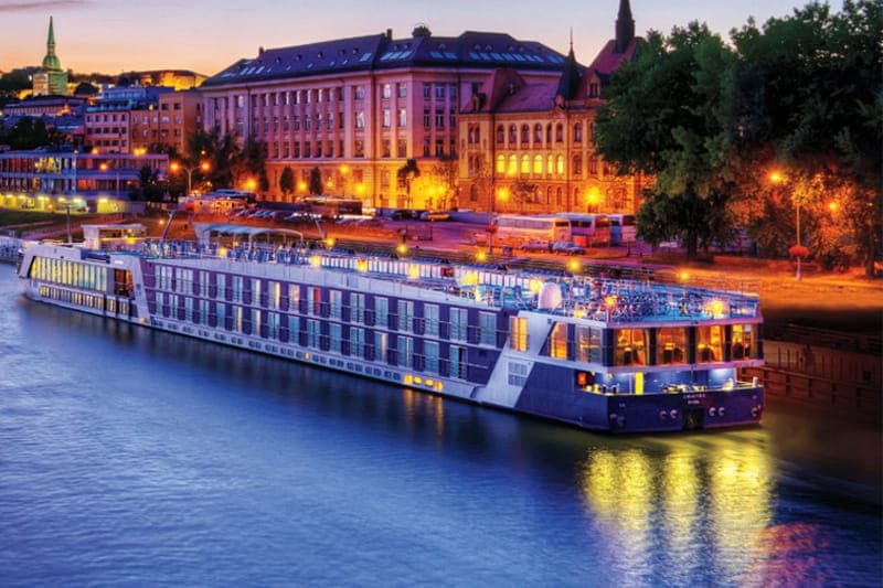 AmaMora moored beneath old-town spires at dusk