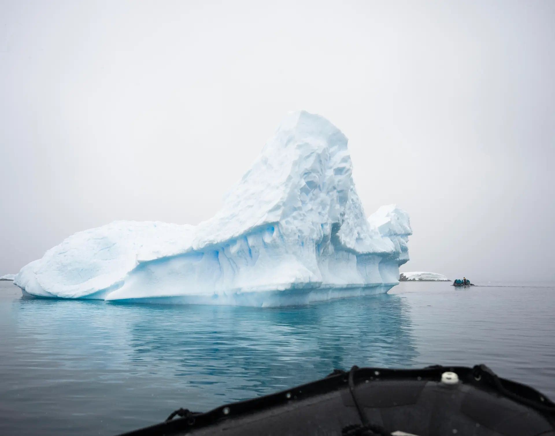 An iceberg looming out of the mist, seen from the zodiac bow